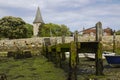 A small wooden jetty covered with barnacles and seaweed in the harbour at Bosham village in West sussex in the South of England Royalty Free Stock Photo