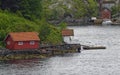 Small Wooden Norwegian Boat sheds with Jettys in an Inlet or Cove on the Rocky shore of Bergen Fjord