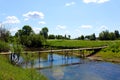 Small wooden pedestrian bridge across the river Royalty Free Stock Photo