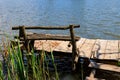 Small wooden pier with bench for fishing on lake Royalty Free Stock Photo
