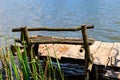 Small wooden pier with bench for fishing on lake Royalty Free Stock Photo