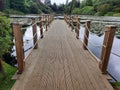 a small wooden pier leading to a pond filled with water lil Royalty Free Stock Photo