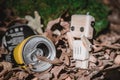 A small wooden robot next to a metal soda can