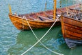 Small wooden sailboats tied to the shore