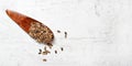 Small wooden scoop with blessed milk thistle seeds - Silybum marianum - on white stone like board, view from above Royalty Free Stock Photo