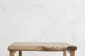 Small wooden table on abstract rough handmade wall background