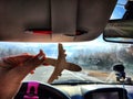 Small wooden toy airplane in the female driver& x27;s hand in a car on the background of the road and highway. The Royalty Free Stock Photo