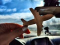 Small wooden toy airplane in the female driver's hand in a car on the background of the road and highway. The Royalty Free Stock Photo