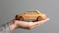 Small wooden toy car in the palm of your hand on a black background. Concept of car insurance, guarantee and protection Royalty Free Stock Photo