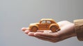 Small wooden toy car in the palm of your hand on a black background. Concept of car insurance, guarantee and protection Royalty Free Stock Photo