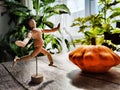 Small wooden toy man is a gardener and farmer with a huge orange or yellow vegetable squash. The concept of a good Royalty Free Stock Photo