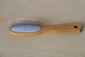 small wooden white comb with metal teeth longitudinal and transverse combing, tools for hair of different thicknesses lie on light