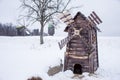 Small wooden windmill in foreground with focus on it and big historical windmills in background against background of winter lands Royalty Free Stock Photo