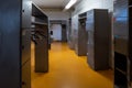 Small work place locker room for workers with opened lockers and yellow floor Royalty Free Stock Photo