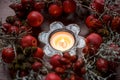 Small wreath with rose hips and red apples around a burning candle as table decoration in autumn, Advent and Christmas time Royalty Free Stock Photo
