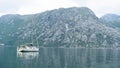 Small Yacht in the Bay of Kotor in Montenegro. Marine boats. Relaxing landscape, boat in a calm sea. Grey mountain with green