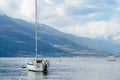 Small yacht docked in the marina of Varenna, one of the most picturesque towns on the shore of Lake Como. Varenna, Italy Royalty Free Stock Photo