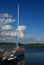 Small yacht and motor boat anchored at wooden pier in marina on Orava river dam, northern Slovakia.