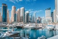 yacht and motor boats parking at the port near Dubai Marina Mall with row of high skyscrapers residential buildings and Royalty Free Stock Photo