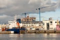 Small yacht sailing into Galway harbor passing by commercial ship.