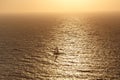 Small yacht in the sea during orange susnset. Royalty Free Stock Photo