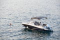 Small yacht with tent roof is moored in Kotor bay