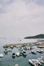 Small yachts are moored in rows at the pier against the backdrop of the mountains