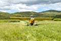 Small aircraft taking off on scenic country meadow Royalty Free Stock Photo