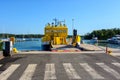 A small yellow car ferry moored at pier