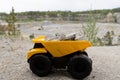 Small yellow car toy, mining truck with stones. Royalty Free Stock Photo