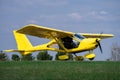 Small yellow charter airplane waiting on a green field to take off Royalty Free Stock Photo