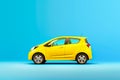 Small yellow electric car on bright blue background Royalty Free Stock Photo