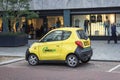 Small yellow electric car parked on the street