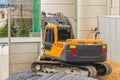 Small yellow excavator working at the construction site. Mini ba