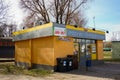 Small yellow grocery store with trash sorting containers in Poznan, Poland.