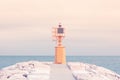 Small yellow lighthouse at the end of the pier against the blue sea Royalty Free Stock Photo