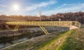 Small yellow metal pedestrian bridge outside the city.