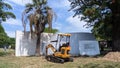 16.04.2023 A small yellow mini excavator with a bucket is excavating in a park in Lisbon