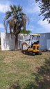 16.04.2023 A small yellow mini excavator with a bucket is excavating in a park in Lisbon