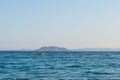 Small yellow motorized boat with one man sails in the open sea