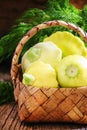 Small yellow pattypan squash or zucchini in a wicker basket, vin