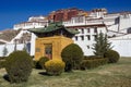 A small yellow pavilion with a green roof and a decorative bush in front of the Potala Palace in Lhasa