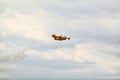 Small yellow red seaplane hydroplane flying in the sky