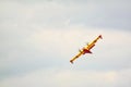 Small yellow red seaplane hydroplane flying in the sky