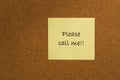 Small yellow sticky note on office noticeboard Royalty Free Stock Photo