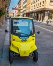 Small yellow three-wheeled vehicle parked on Ugo Bassi avenue in Bologna, Italy Royalty Free Stock Photo