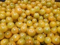 Small yellow tomatoes in bulk uniform background.