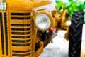 Small yellow tractor in exhibition, closeup details, wheels