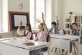 Group of elementary school students raise their hand in class to answer the teacher's questions. Royalty Free Stock Photo