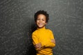 Smart African American child student boy on chalkboard background with science formulas
